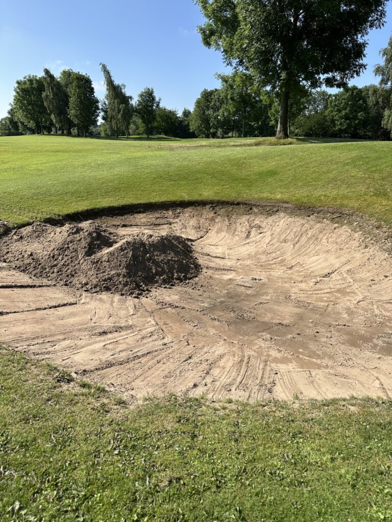 Douglas Valley Golf Club sand bunker in the process of being dug out. Sand bunker with digger marks and pile of sand in Blackrod, Bolton